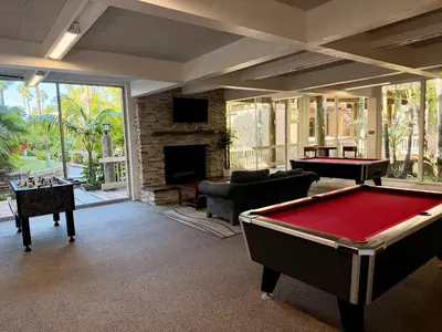 a living room with a pool table and a fireplace at Stunning Oceanview Penthouse | 2BR, Sleeps 6 | North Coast Village Resort in Oceanside