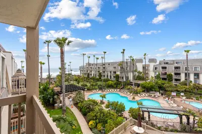a view of the pool from the balcony of a resort at Stunning Oceanview Penthouse | 2BR, Sleeps 6 | North Coast Village Resort in Oceanside