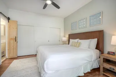 a bedroom with a white bed and a ceiling fan at Carlsbad Coastal Cottage — Private Patio + Gated Pool & Spa in Minutes to the Beach! in Carlsbad