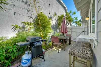 a patio with a grill and a table and chairs at Carlsbad Coastal Cottage — Private Patio + Gated Pool & Spa in Minutes to the Beach! in Carlsbad
