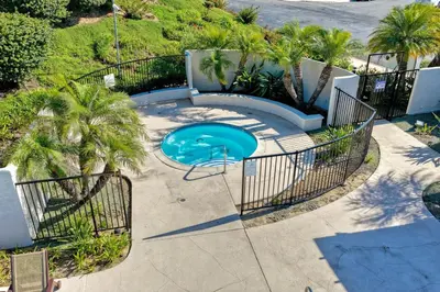 an overhead view of a swimming pool with palm trees at Carlsbad Coastal Cottage — Private Patio + Gated Pool & Spa in Minutes to the Beach! in Carlsbad