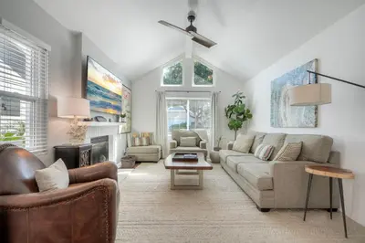 a living room with a couch and a fireplace at Carlsbad Coastal Cottage — Private Patio + Gated Pool & Spa in Minutes to the Beach! in Carlsbad