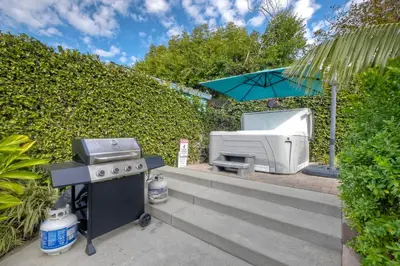 a barbecue grill and a microwave in a garden at Luxury 3-Bed Beach Cottage with Hot Tub, Fire Pit, BBQ - Walk To Beach in Cardiff-by-the-Sea