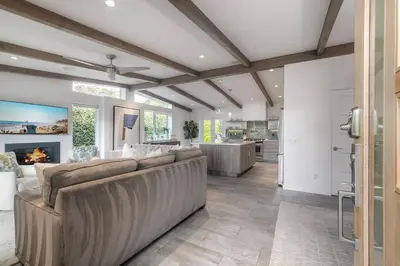 a living room with a couch and a fireplace at Luxury 3-Bed Beach Cottage with Hot Tub, Fire Pit, BBQ - Walk To Beach in Cardiff-by-the-Sea