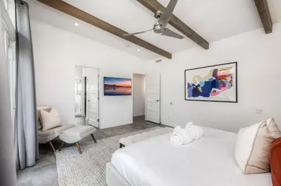 a white room with a bed and a couch at Luxury 3-Bed Beach Cottage with Hot Tub, Fire Pit, BBQ - Walk To Beach in Cardiff-by-the-Sea
