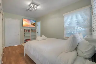 a bedroom with a white bed and a window at Coastal Cottage Steps from the Sand | Walk to Carlsbad Village, Dog-Friendly in Carlsbad