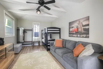 a living room with a couch and a bunk bed at Coastal Cottage Steps from the Sand | Walk to Carlsbad Village, Dog-Friendly in Carlsbad