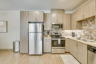 a kitchen with stainless steel appliances and wooden cabinets at By Seaport Village and Navy Base! Chic Condo with Pool in National City