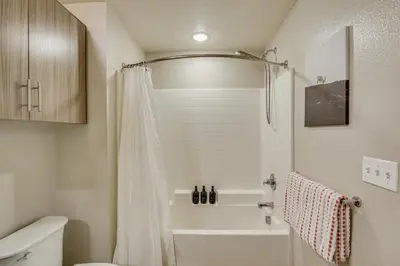 a bathroom with a shower curtain and a toilet at By Seaport Village and Navy Base! Chic Condo with Pool in National City