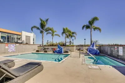 a swimming pool at a resort with palm trees at By Seaport Village and Navy Base! Chic Condo with Pool in National City