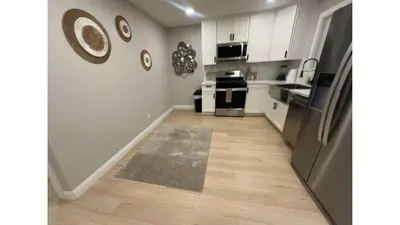 a kitchen with white cabinets and a wooden floor at 321 W Park El Cajon Back Unit by Sd stay in El Cajon