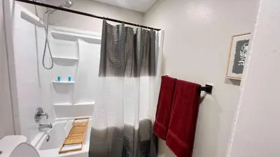 a bathroom with a shower curtain and red towels at 321 W Park El Cajon Back Unit by Sd stay in El Cajon