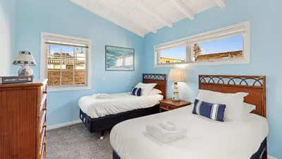 two beds in a room with blue walls and windows at Oceanfront Atelier by AvantStay Beachfront Balboa Peninsula Escape in Newport Beach