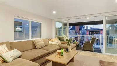 a living room with a couch and a table at Seabright Sky by AvantStay Top-Floor West Newport Retreat • Balcony Near Beach Cafes in Newport Beach