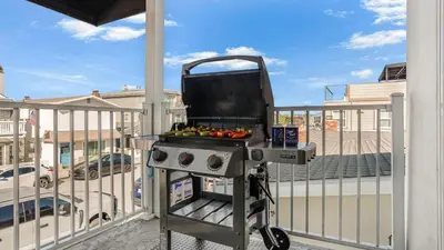 a barbecue on a balcony with a grill at Seabright Sky by AvantStay Top-Floor West Newport Retreat • Balcony Near Beach Cafes in Newport Beach