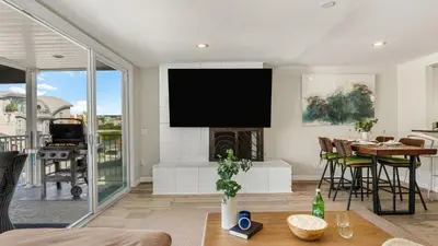 a living room with a fireplace and a tv at Seabright Sky by AvantStay Top-Floor West Newport Retreat • Balcony Near Beach Cafes in Newport Beach
