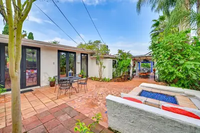 an outdoor patio with a couch and a table and chairs at Gather and Unwind Outdoors, Stylish Vista Retreat! in Vista