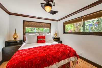 a bedroom with a large bed with a red blanket at Gather and Unwind Outdoors, Stylish Vista Retreat! in Vista