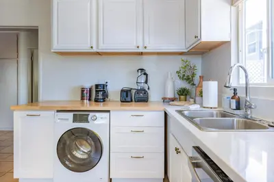 a kitchen with a washing machine and a sink at Light & Airy by Coastline Vacation Rentals in San Diego