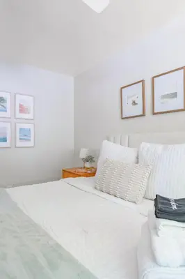 a white bedroom with a bed and a table at Light & Airy by Coastline Vacation Rentals in San Diego