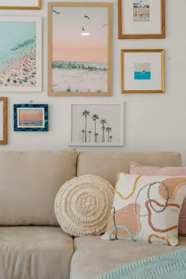 a living room with a couch and pictures on the wall at The Palm House by Coastline Vacation Rentals in San Diego