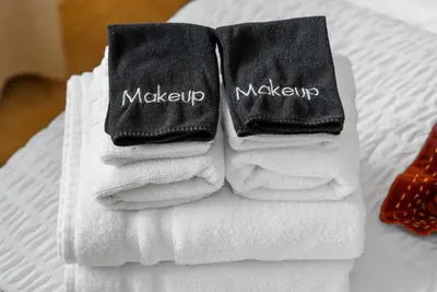 a pile of towels sitting on top of a bed at The Palm House by Coastline Vacation Rentals in San Diego