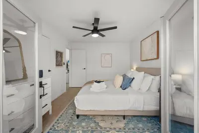 a bedroom with a bed and a ceiling fan at The Palm House by Coastline Vacation Rentals in San Diego