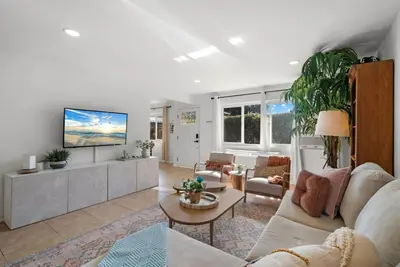 a living room with a couch and a tv at The Palm House by Coastline Vacation Rentals in San Diego
