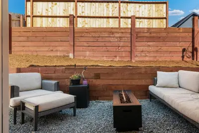 a patio with two couches and a wooden wall at The Palm House by Coastline Vacation Rentals in San Diego