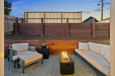 a patio with two couches and a coffee table and a fence at The Palm House by Coastline Vacation Rentals in San Diego
