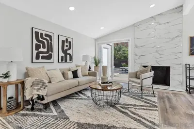 a living room with a couch and a fireplace at Poolside Paradise in Central SD in San Diego