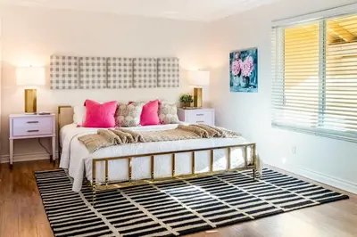 a bedroom with a large bed with pink pillows at Hilltop Wine Estate- Pickleball - Pool - 360 views in Temecula