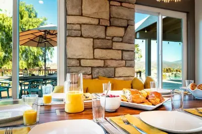 a table with breakfast food on a table with a view at Hilltop Wine Estate- Pickleball - Pool - 360 views in Temecula