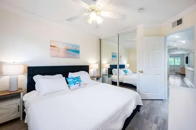 a bedroom with a white bed and a ceiling fan at Luxe 2-Story Oasis with Private Pool & Backyard in Laguna Niguel