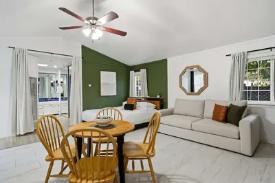 a living room with a bed and a table and chairs at 4BR Family Retreat with Hot Tub Games & Fire Pit in Chula Vista