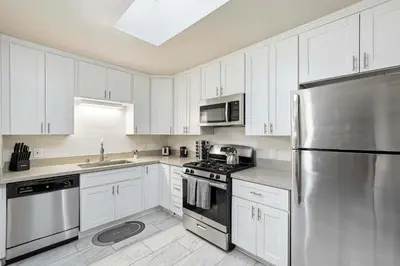 a kitchen with white cabinets and a stainless steel refrigerator at 4BR Family Retreat with Hot Tub Games & Fire Pit in Chula Vista