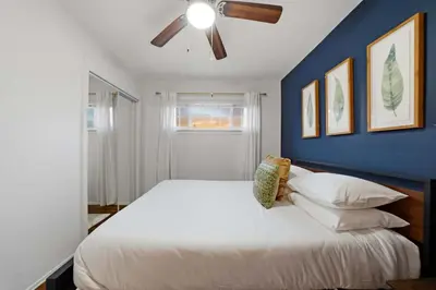 a bedroom with a large white bed with a blue wall at 4BR Family Retreat with Hot Tub Games & Fire Pit in Chula Vista