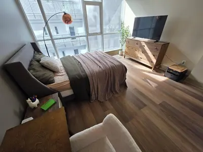 a bedroom with a bed and a tv and a couch at Downtown Beautiful 3-bedroom Apartment Steps to Convention Center, Petco Park! in San Diego