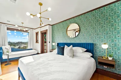 a bedroom with a large bed with a blue wall at Top 2 Floors Historic Mansion Game Room City Views in San Diego