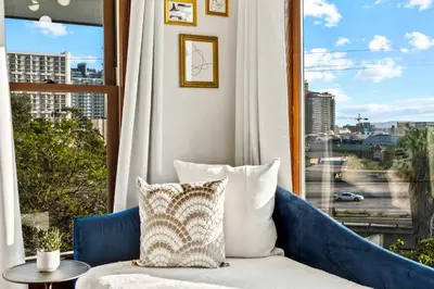 a living room with a blue couch and a large window at Top 2 Floors Historic Mansion Game Room City Views in San Diego