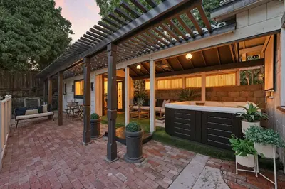 an outdoor patio with a hot tub and a pergola at Iconic Mansion with Hot Tub GYM Arcade and Parking in San Diego