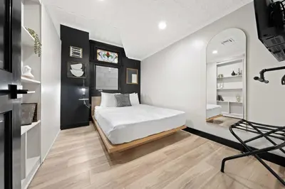 a bedroom with a bed and a mirror at Iconic Mansion with Hot Tub GYM Arcade and Parking in San Diego
