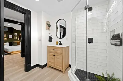 a bathroom with a shower with a sink and a mirror at Iconic Mansion with Hot Tub GYM Arcade and Parking in San Diego