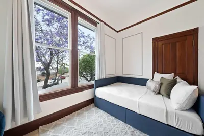 a bed sitting in a room with a window at Iconic Mansion with Hot Tub GYM Arcade and Parking in San Diego