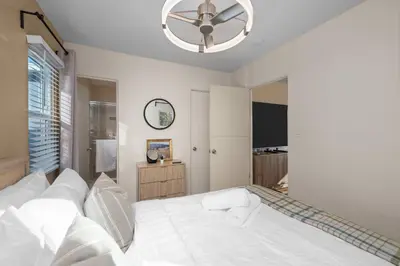 a bedroom with a white bed with a ceiling fan at Stylish 1BR Home with Parking Near Zoo & Downtown in San Diego