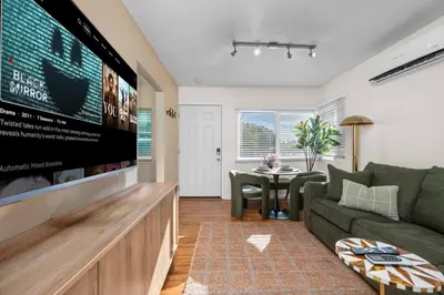 a living room with a large flat screen tv at Stylish 1BR Home with Parking Near Zoo & Downtown in San Diego