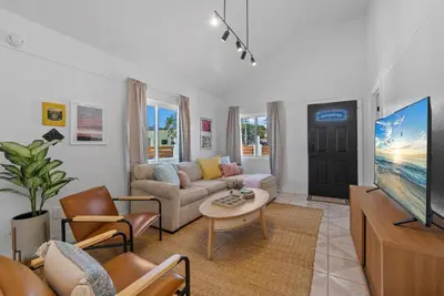 a living room with a couch and a tv at Barrio Bungalow by Coastline Vacation Rentals in San Diego
