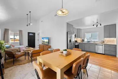 a kitchen and living room with a table and chairs at Barrio Bungalow by Coastline Vacation Rentals in San Diego