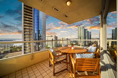 a balcony with a table and chairs and a view of the city at Electra Building 2bed - Views Pool Sauna Spa in San Diego