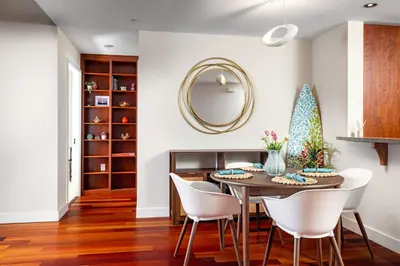 a dining room with a table and chairs and a mirror at Electra Building 2bed - Views Pool Sauna Spa in San Diego